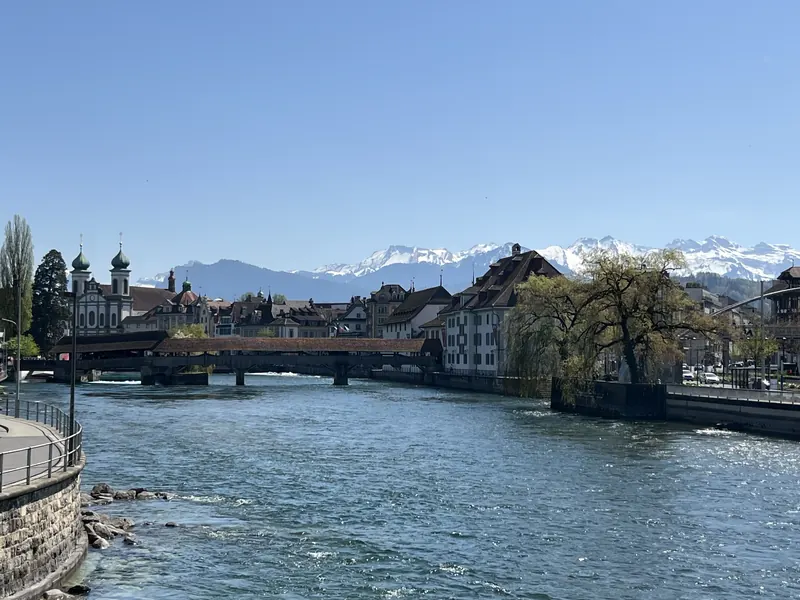 Luzern: die Jesuitenkirche an der Reuss, dahinter die verschneiten Alpen